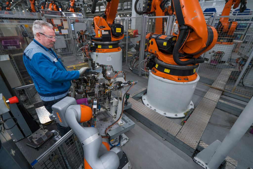 bmw worker in workshop with robots
