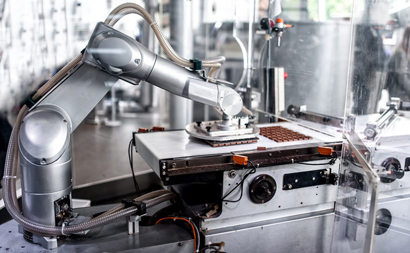 automatic robotic hand moving and preparing bits of chocolate