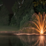 Illuminated aeration fountain on a pond.